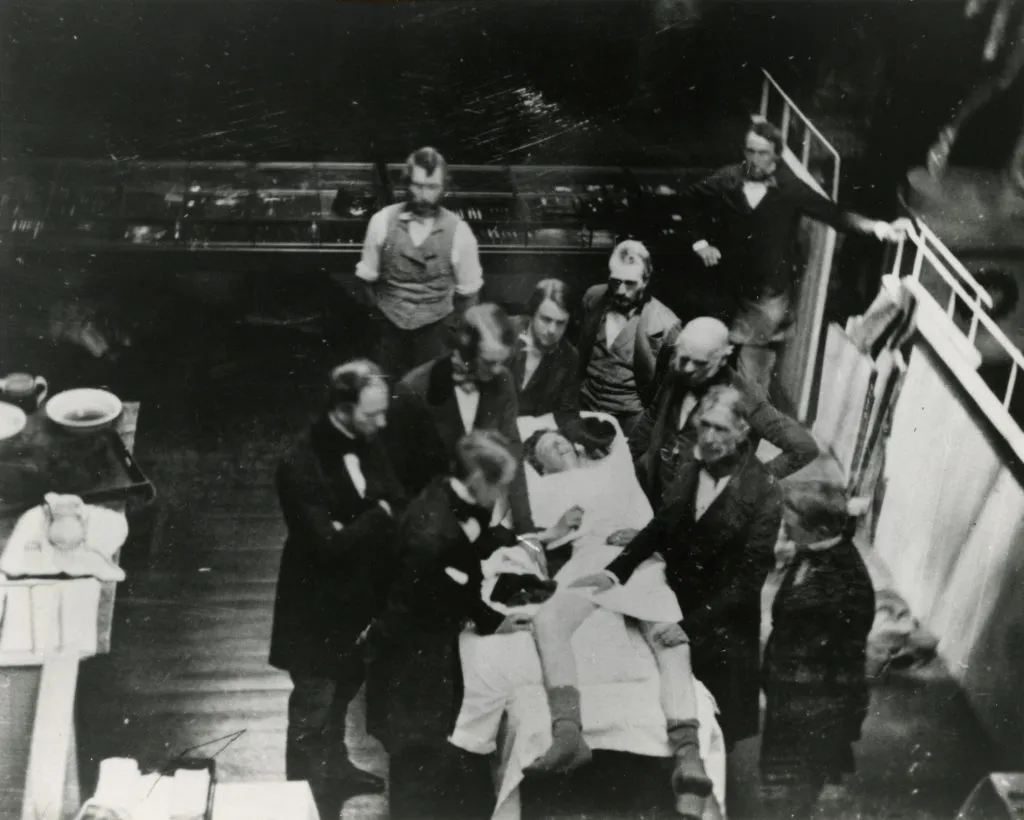 Ein Fototermin von 1847 im Ether Dome. Der Chirurg John Collins Warren hält die Beine des Patienten. William TG Morton steht am Kopf des Patienten und verabreicht ihm Äther.
