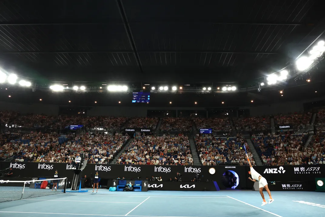 eine dunkle Tennisarena mit geschlossenem Dach